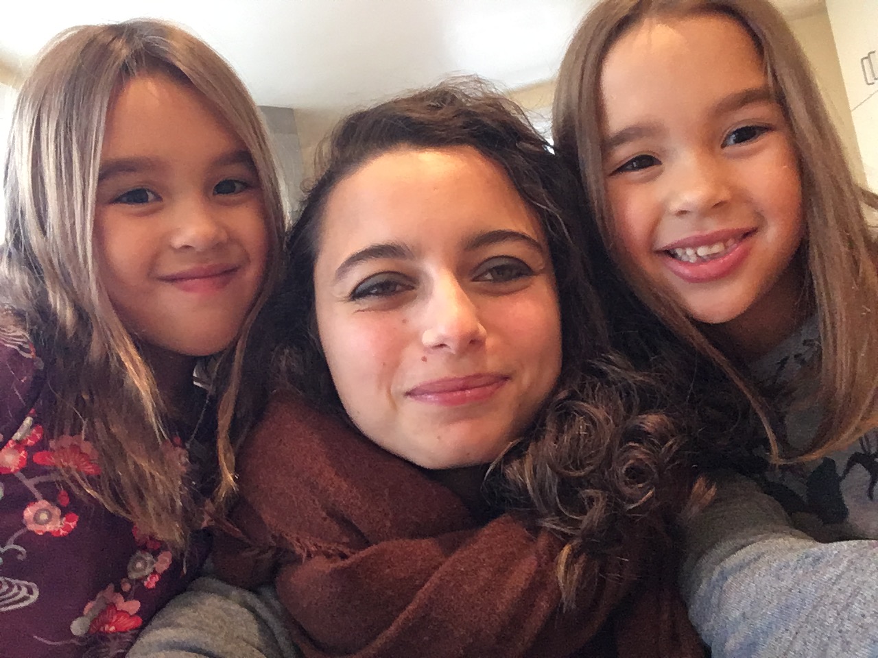 Au Pair Amandine is taking a selfie with her two 6 year old host girls.