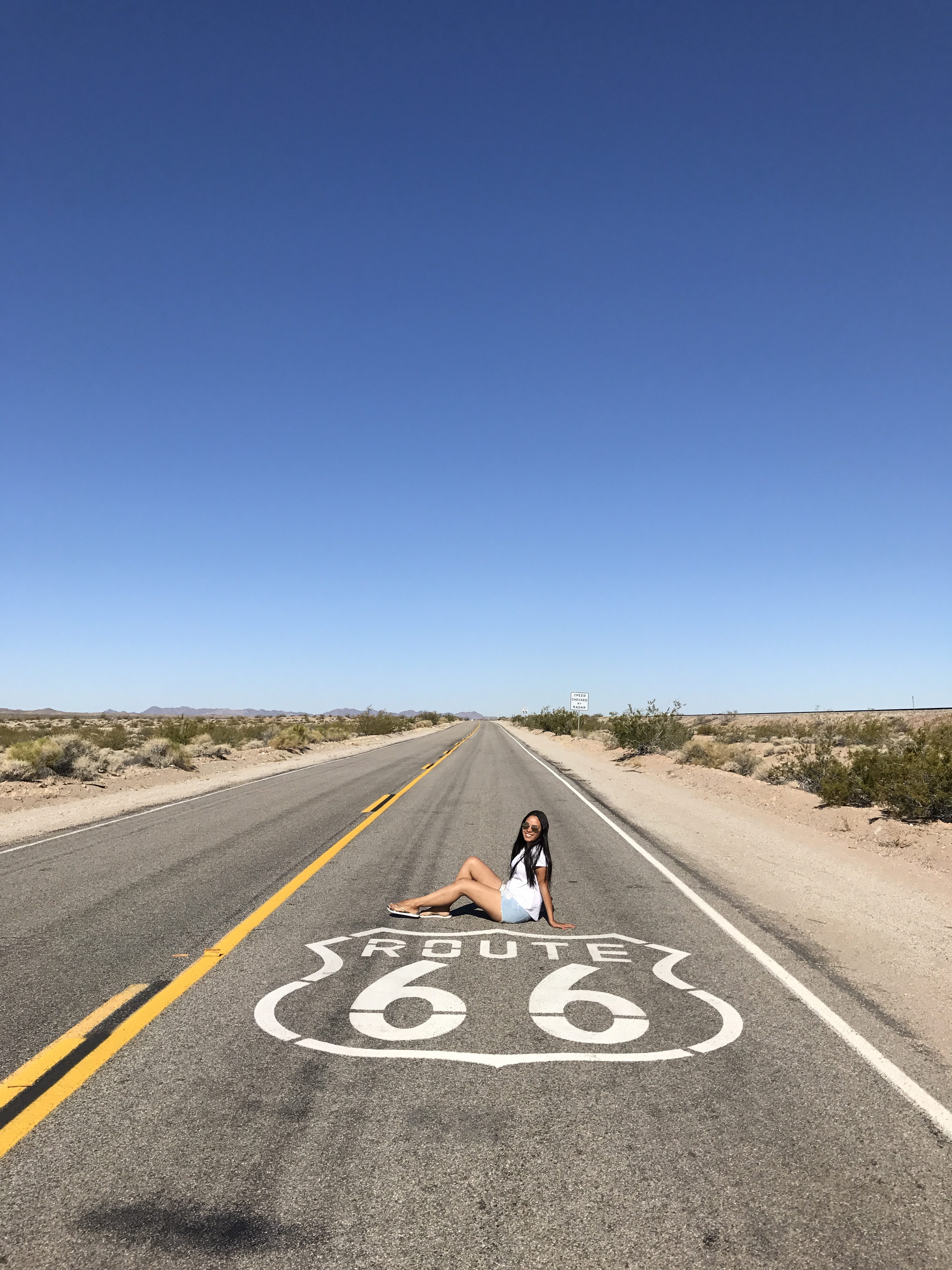 Mariana sat down in the middle of Route 66, a clear blue sky above her.
