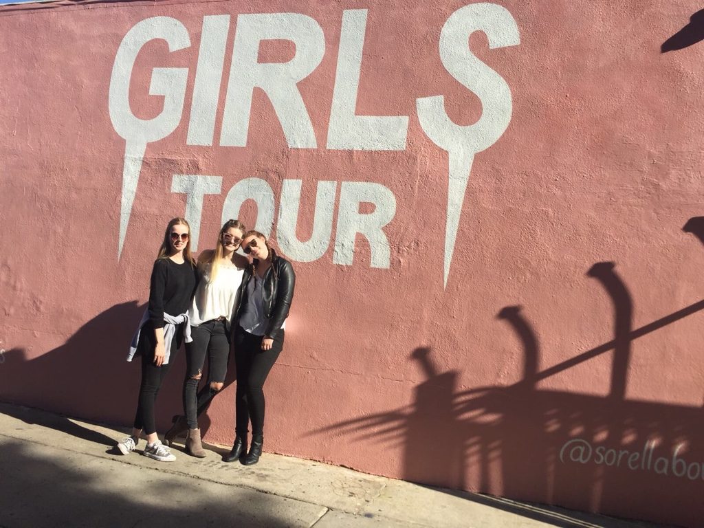 Vanessa and her two friends Franzi and Nele in front of another Melrose Avenue wall that says "Girls Tour".