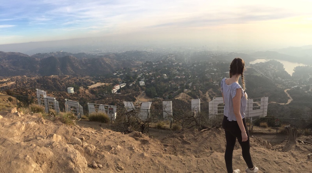 Vanessa standing in front of the back side of the infamous Hollywood Sign