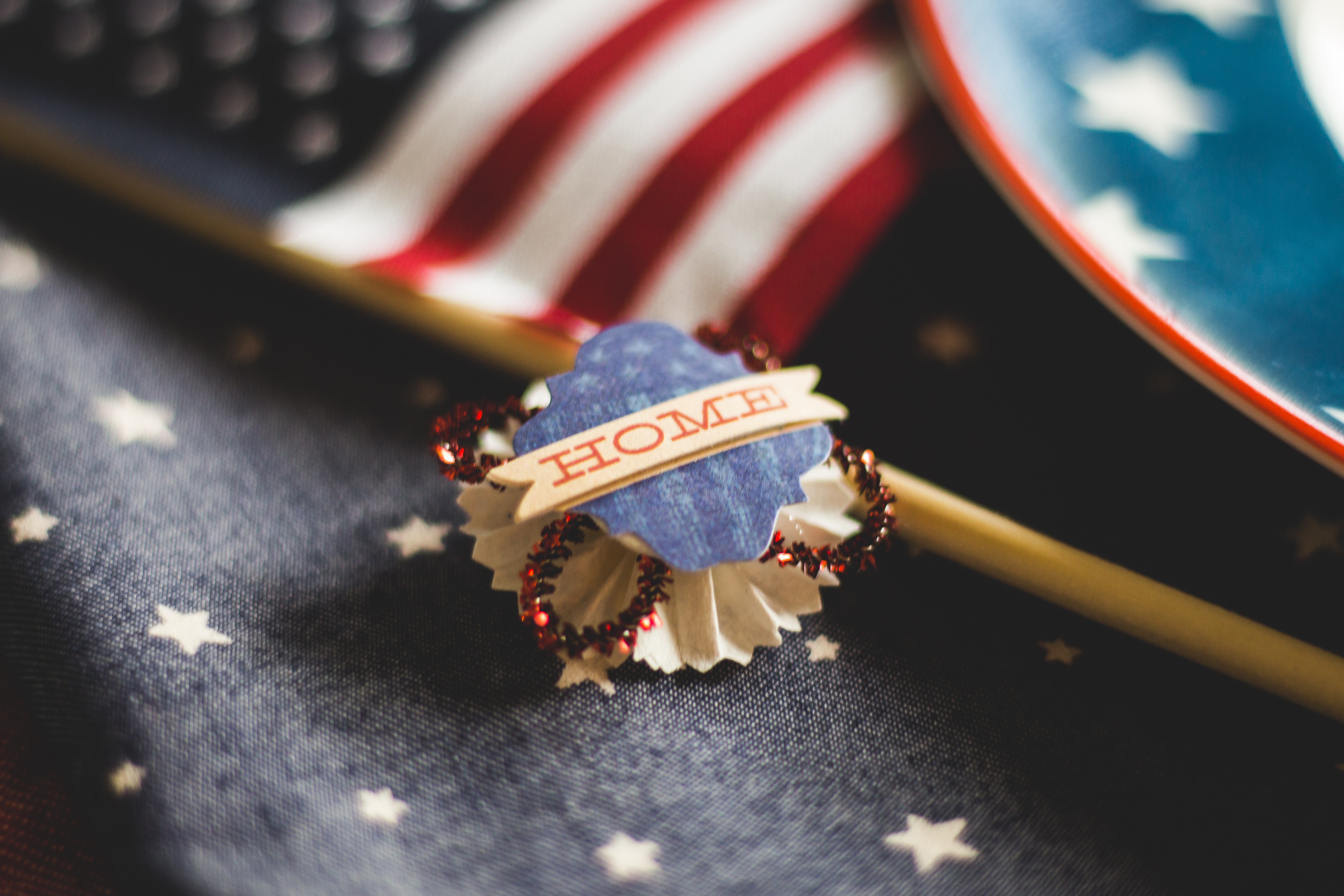 A button badge that says "home", lying on top of an American flag.