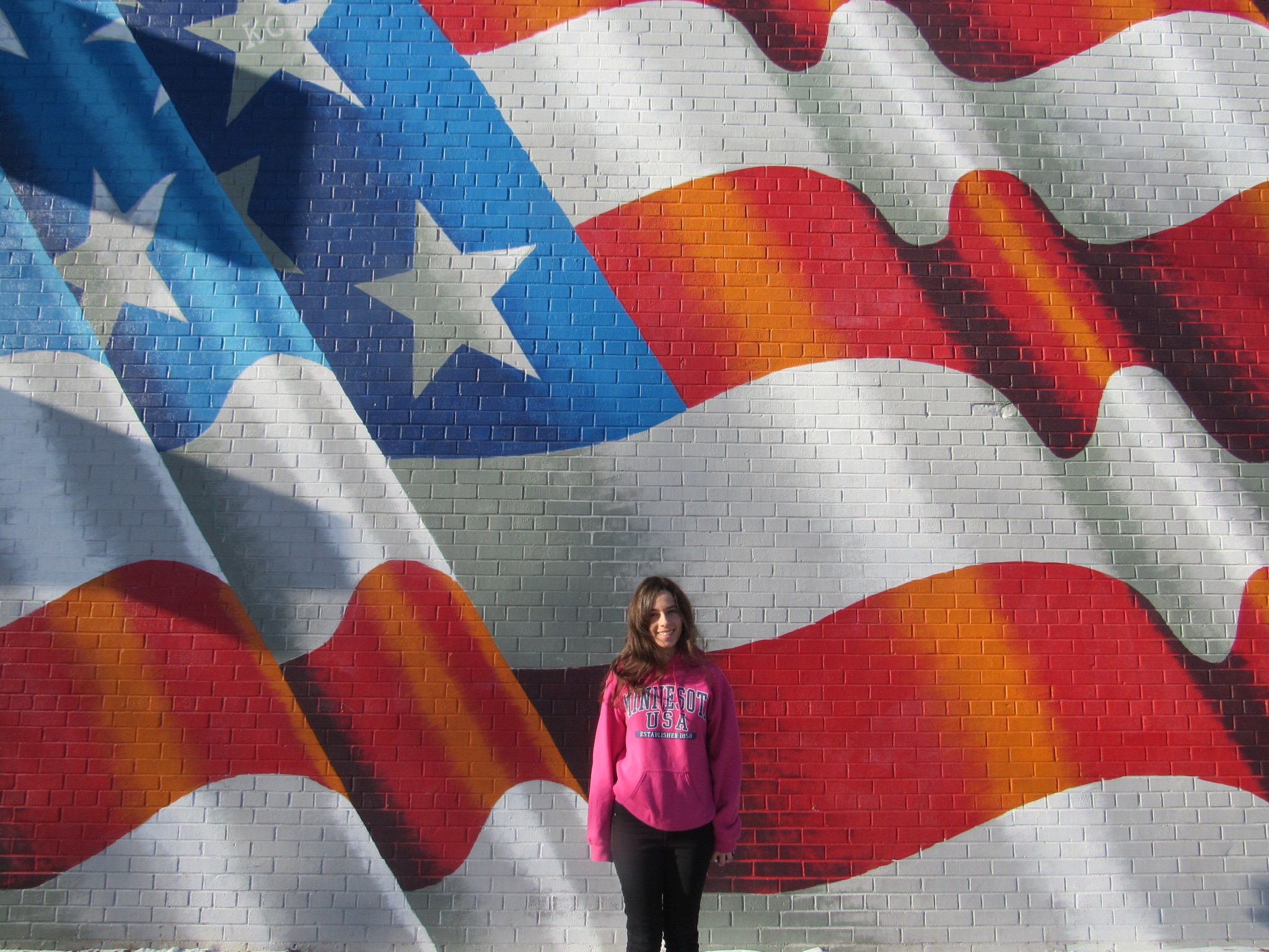 MAria stood in front of an American Flag wall artwork